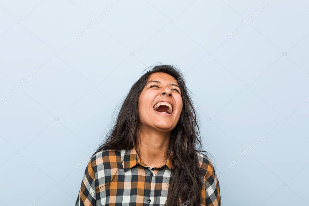 Young cool indian woman relaxed and happy laughing, neck stretched showing teeth.
