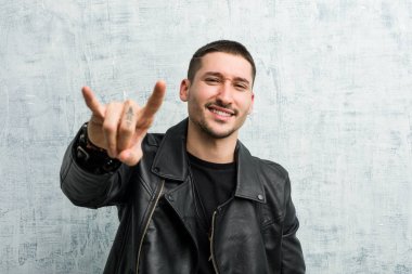 Genç rockçı adam bir devrim konsepti olarak boynuzlarını gösteriyor..