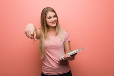 Genç, güzel Rus kız neşeli ve gülümsüyor. Elinde kitaplar var..