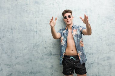 Mayo giyen genç beyaz adam kameraya sarıldığı için kendinden emin..