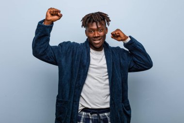 Genç Afrikalı siyah adam pijama giyip özel bir günü kutluyor..