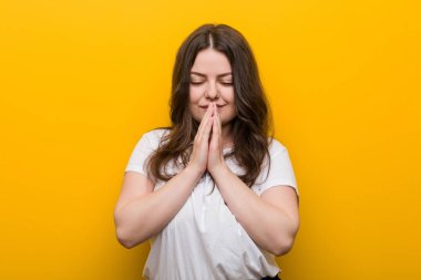 Genç kıvrımlı artı boyutu kadın ağız ayakın dua el ele tutuşarak, kendinden emin hissediyor.