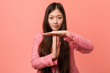 Pembe takım elbiseli genç Çinli kadın mola veriyor..