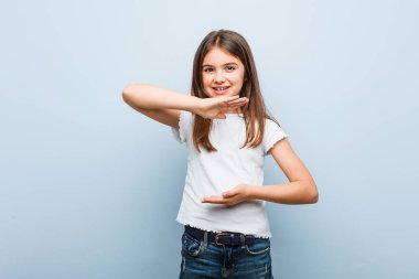 Sevimli kız iki eliyle bir şey tutarak, ürün sunumu.