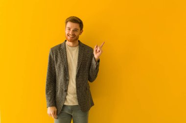 Genç kızıl saçlı iş adamı parmağıyla kenarı işaret ediyor.