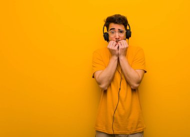 Genç adam müzik dinliyor tırnak yiyor, gergin ve çok endişeli.