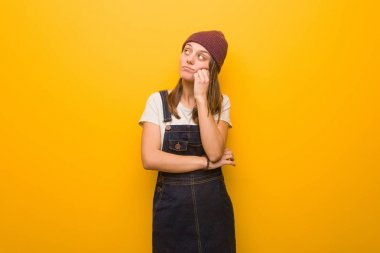 Genç hippi kadın bir şeyler düşünüyor, yana bakıyor.