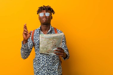 Genç Rasta siyahi adam şans dilemek için bir harita tutuyor.