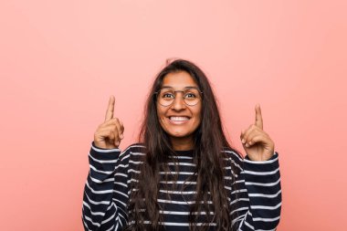 Genç entellektüel Hintli kadın iki elini de havaya kaldırarak boş bir alan gösteriyor..