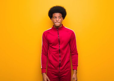 Turuncu bir duvarın üstünde genç bir zenci bir fikir düşünüyor.