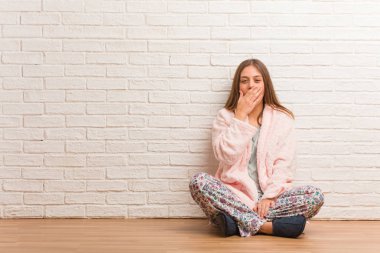 Pijama giyen genç bir kadın yorgun ve çok uykulu.