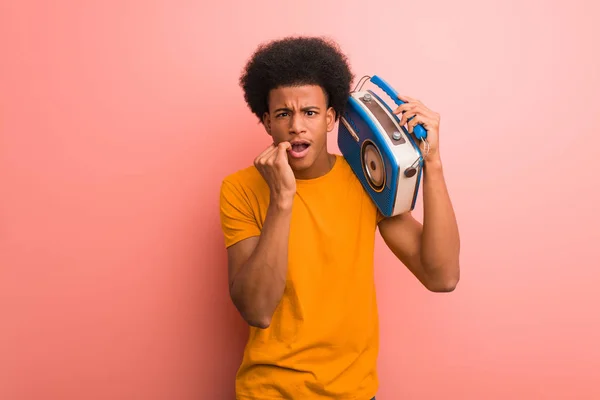 若いアフリカ系アメリカ人を保持しているヴィンテージラジオかむ爪 神経と非常に不安 — ストック写真