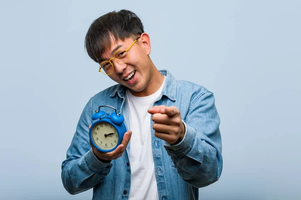 Jovem Chinês Segurando Despertador Alegre Sorrindo Apontando Para Frente — Fotografia de Stock