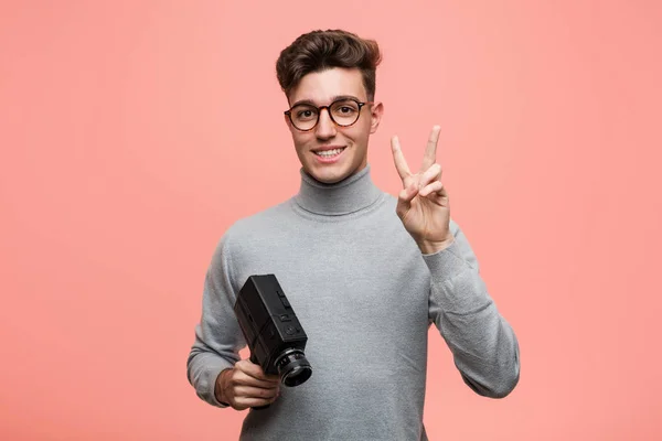 Jovem Intelectual Segurando Uma Câmera Filme Mostrando Número Dois Com — Fotografia de Stock