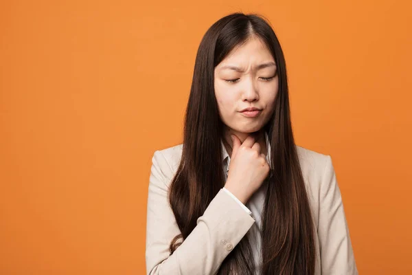 Young business chinese woman suffers pain in throat due a virus or infection.