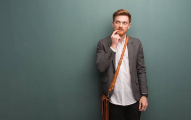 Genç kızıl saçlı iş adamı şüphe ve karışık