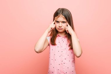 Sevimli küçük kız bir görev üzerinde duruldu, onu işaret parmakları baş işaret tutmak.