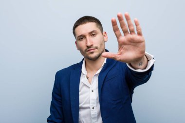 Genç beyaz adam elini uzatmış, dur işareti göstererek seni engelliyor..