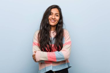 Kendine güveni olan genç moda Hintli kadın, kararlılıkla kollarını kavuşturuyor..