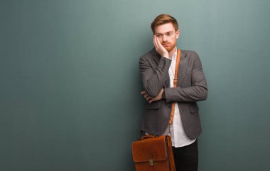 Genç kızıl saçlı iş adamı yorgun ve çok uykulu.