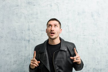 Genç rockçı ağzı açık bir şekilde yukarı işaret ediyor..