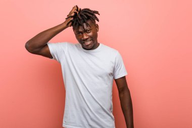 Genç Afrikalı siyahi adam yorgun ve uykulu ellerini başının üstünde tutuyor..