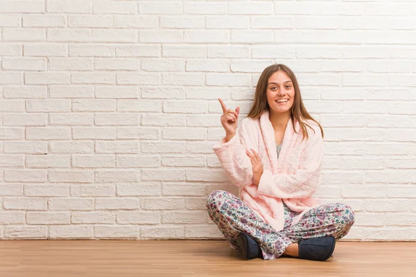 Jonge Vrouw Draagt Pyjama Wijzend Naar Zijkant Met Vinger — Stockfoto