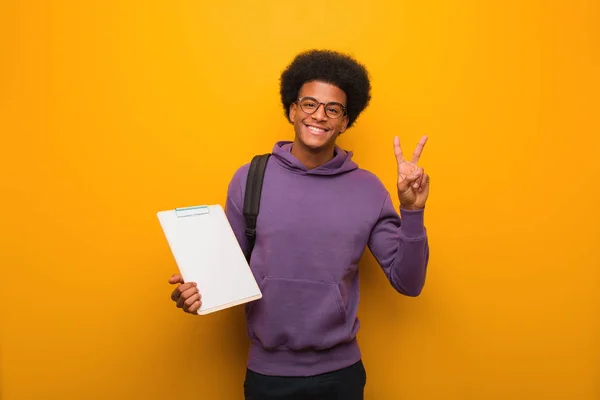 Jovem Estudante Afro Americano Segurando Uma Prancheta Mostrando Número Dois — Fotografia de Stock