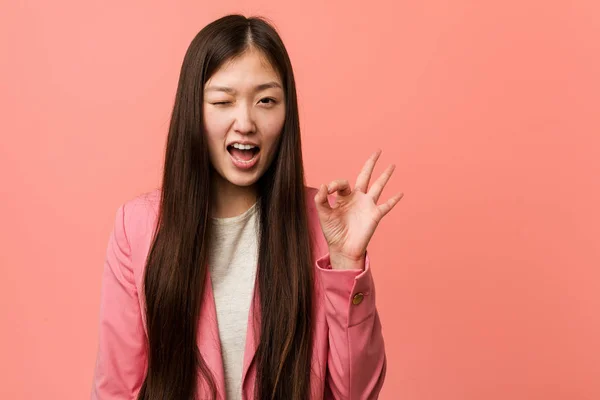 Young Business Chinese Woman Wearing Pink Suit Winks Eye Holds — 스톡 사진