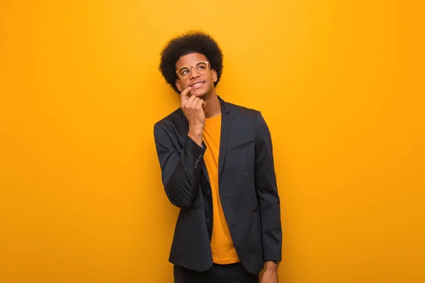 Giovane Uomo Affari Afro Americano Muro Arancione Rilassato Pensando Qualcosa — Foto Stock
