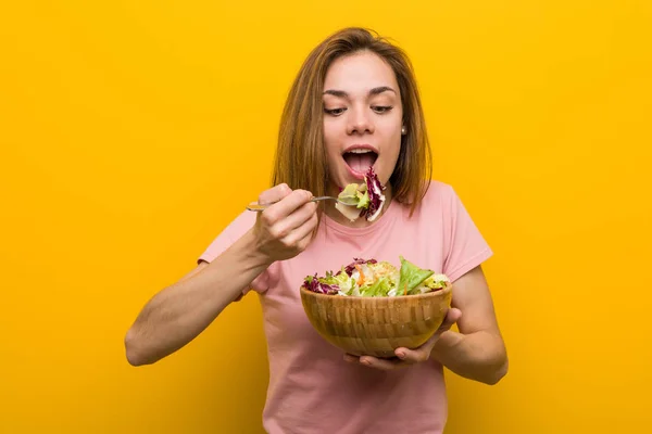 Vegan young woman eating a fresh and delicious salad.