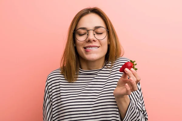 Retrato de mujer joven degustando una fresa fresca —  Fotos de Stock