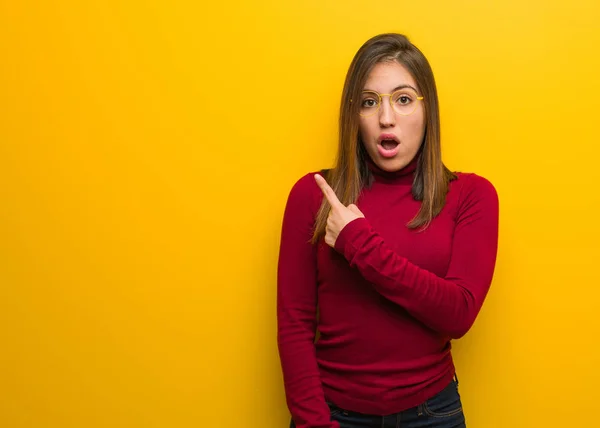 Young intellectual woman pointing to the side