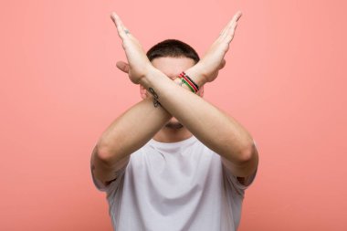 Kollarını kavuşturup inkar eden genç bir adam..