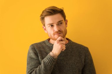 Genç kızıl saçlı adamın yüzü kuşkulu ve kafası karışık.