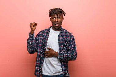 Genç Afrikalı siyahi adam başının arkasına dokunuyor, düşünüyor ve bir seçim yapıyor..