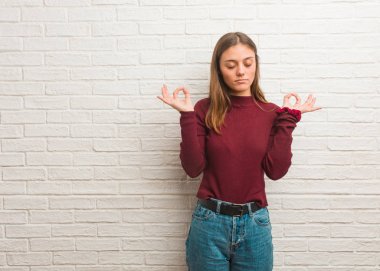 Duvarın üzerinden yoga yapan havalı bir kadın.