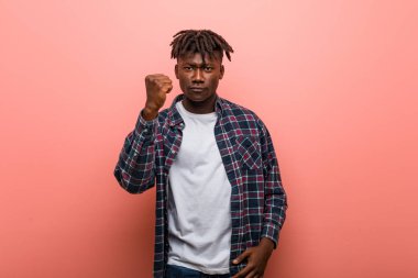 Genç Afrikalı siyahi adam kameraya yumruğunu gösteriyor, agresif yüz ifadesi..