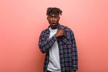 Genç Afrikalı siyahi adam yan tarafı gösteriyor.