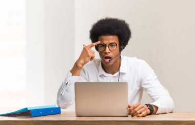 Genç pazarlamacı siyah adam parmağıyla hayal kırıklığı jesti yapıyor.