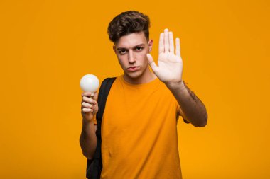 Elinde ampul tutan genç bir öğrenci şakağını parmağıyla işaret ederek bir göreve odaklandı..