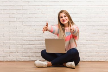 Genç Rus öğrenci çok mutlu bir şekilde oturuyor ve ön tarafa sarılıyor.