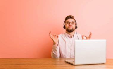 Çağrı merkezinde çalışan genç adam yoğun bir günün ardından dinleniyor, yoga yapıyor..