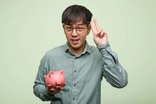Ung Asiatisk Man Håller Spargris Kul Och Glad Gör Gest — Stockfoto