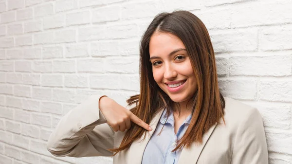 Young business woman person pointing by hand to a shirt copy space, proud and confident