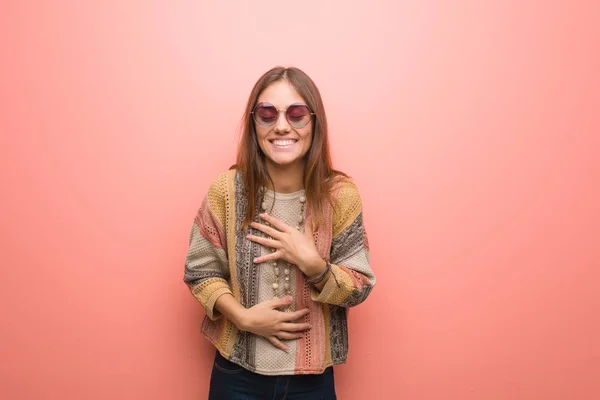Young hippie woman on pink background laughing and having fun