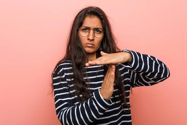 Young intellectual indian woman showing a timeout gesture.