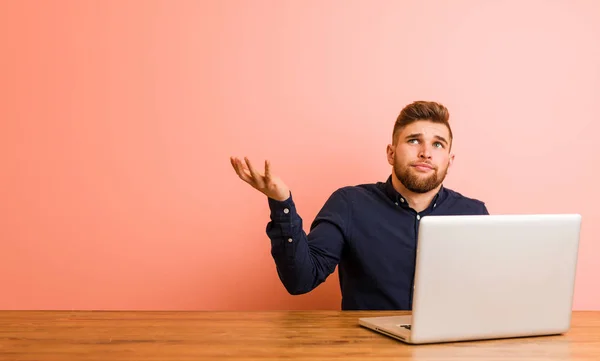 Young Man Working His Laptop Doubting Two Options — 스톡 사진