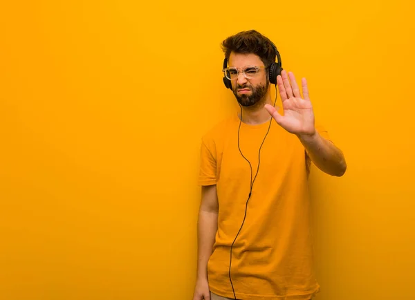 Ung Man Lyssnar Musik Sätta Hand Framför — Stockfoto