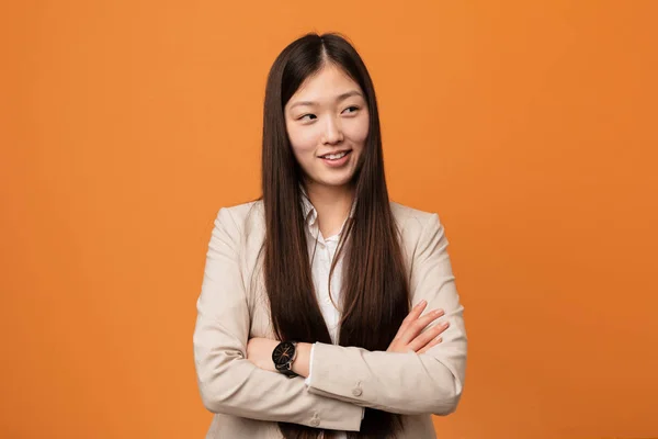 Young business chinese woman smiling confident with crossed arms.